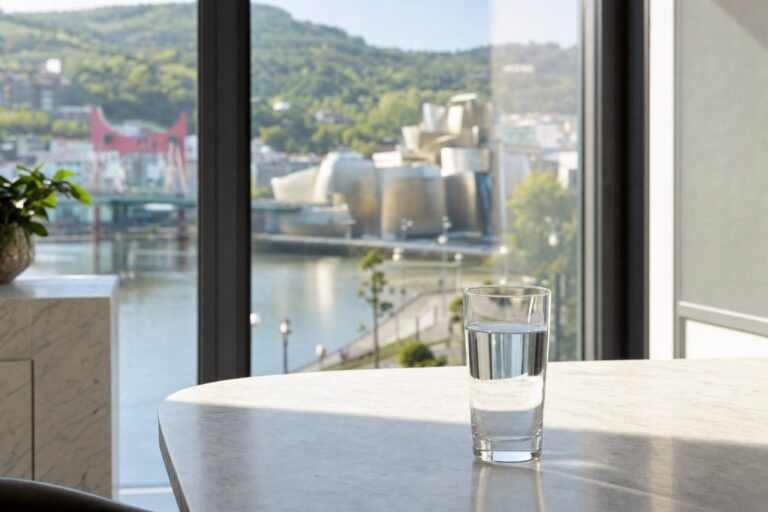 Vaso de agua en una mesa con vistas a la ría de Bilbao